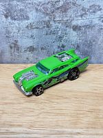 Front and side view of lime green Hot Wheels Jack Hammer car showing twin engines and wheels