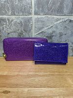 Front view of both purple glitter wallets