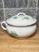 Tureen with lid, front view showing handles and floral decoration