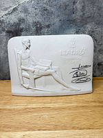 Front view of plaque showing Don Quixote relief and signatures