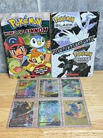 overview of two Pokémon books and six foil cards in top-loaders