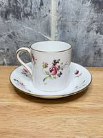 Cup on saucer showing floral pattern and gold trim