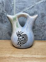 Front view showing Kokopelli motif and twin spouts