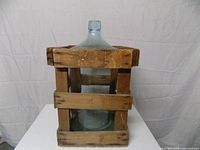 Demijohn inside wooden crate, front view