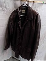 Front view of brown leather overcoat on hanger