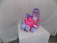 Front left view showing propeller, wheels, push handle, Minnie figure