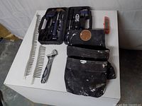 Overall view showing all items laid out including pouch, tool case, wrench, utility knife, screw strips