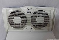 Front view of Holmes dual window fan showing grille, dual blades, control panel