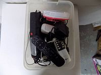 Assorted electronics piled in plastic bin