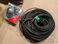 Large coil of black braided cable alongside packaged pendant kit
