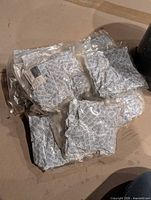 Stacks of sealed plastic sleeves filled with blue-print desiccant packets