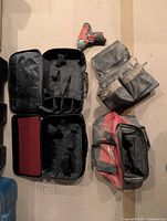 Lot overview showing open Milwaukee cases, duffel bag, belt pouch and impact driver
