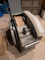 Dispenser interior showing feed rollers, cutting blade and tape path