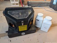 Cabinet front with two abrasive media bottles