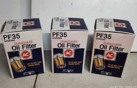 Front view of three boxed AC Duraguard PF35 oil filters
