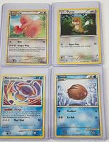 Front view of the four Pokémon cards in sleeves