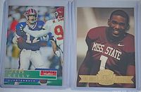 Fronts of Jim Kelly SkyBox card and Eric Moulds Press Pass card in sleeves