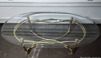 Full view of oval glass coffee table showing frame and legs