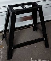 Front angled view of assembled black metal tool stand