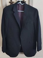 Front view of dark pinstripe boys suit coat on hanger