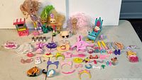 Full lot overview showing dolls, accessories, cart, chair