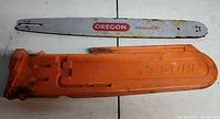 Oregon AdvanceCut guide bar alongside orange Stihl scabbard