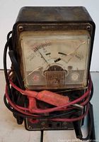 Front view of Superior Instruments analog utility tester multimeter with leads wrapped around unit