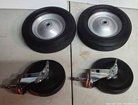 Two cart wheels and two swivel casters laid out