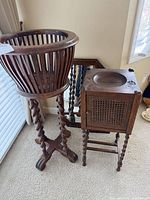 Round slatted jardinière stand and cane-front cabinet stand with mirror behind