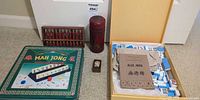Overall lot showing tin, abacus, red cylinder, small wooden box, open tile box with booklet