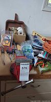 Overall lot showing bench vise, screwdrivers, multimeter, cord, drill bits, hacksaw