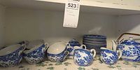 Full tea set on shelf showing teapot, sugar bowl, creamer, cups, saucers