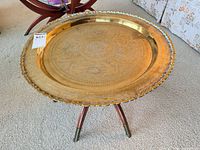 Full view of brass tray table on tripod wooden legs