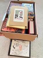 Box with assorted books showing titles such as Oliver Twist and The Power of Style