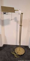 Full view of brass adjustable floor lamp showing shade, stem and base
