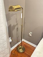 Full view of brass adjustable floor lamp in corner