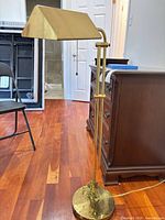 Full view of brass adjustable floor lamp showing height and base