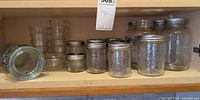 Shelf view showing mason jars, latch canister on side, stacked juice glasses
