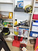 Shelf with compressor box, socket cases, bungee cords, heater, cleaning products, shovel and fluid jugs