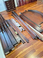 All bed components laid out: four turned posts, side rails, slats, headboard, footboard