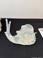 Left side view of clear glass snail showing white lattice swirl shell and extended antennae