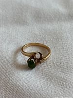 Top view of gold ring showing jade cabochon and empty setting