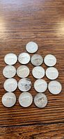 Sixteen Canadian quarters arranged on table