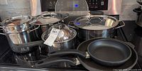 Group view: two Swiss Diamond fry pans, stainless pots with lids, steamer basket