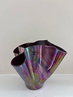 Front view showing ruffled rim and iridescent finish with studio sticker