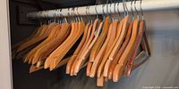 Row of wooden suit hangers on closet rod