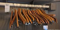 Group of wooden suit hangers and pant hangers on closet rod