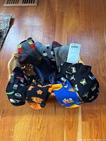 Basket containing seven pairs of novelty men’s socks, navy pocket square visible