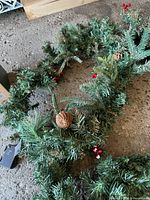 Overall view of garland with pinecone, berry accents and battery pack