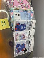 Five sealed kids neck gaiter packages with assorted designs